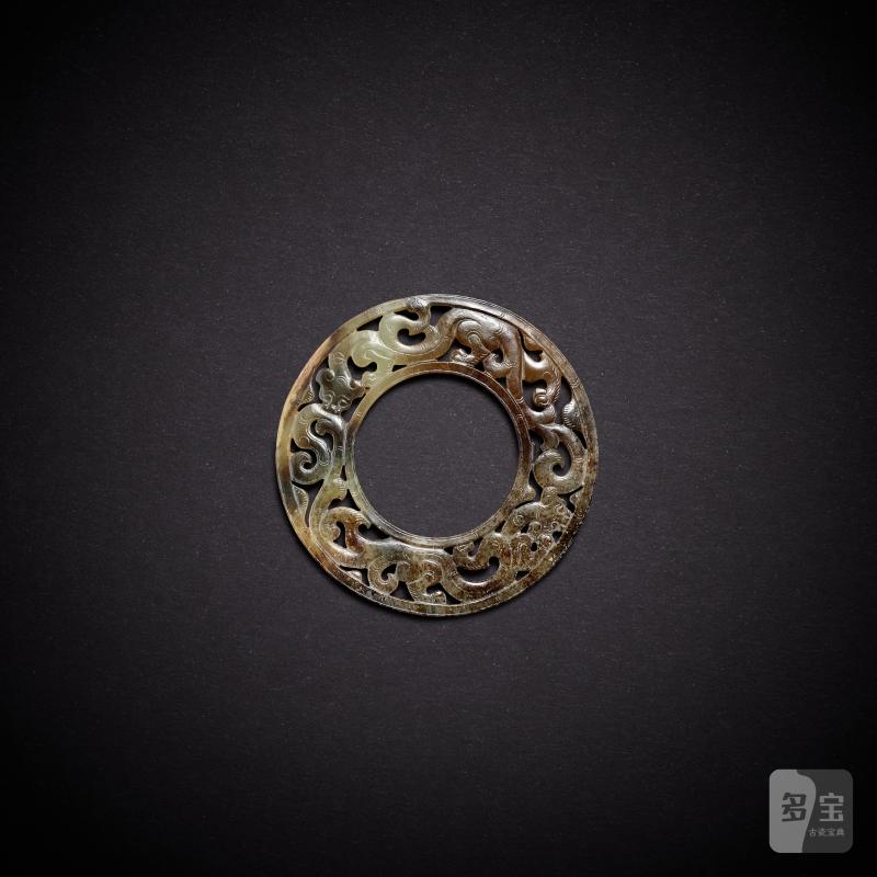 A pale celadon and russet jade 'chilong' pendant, huan, Western Han dynasty | 西漢 青白玉鏤雕龍紋環